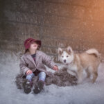 Vicky Champagne captured this moment between child with her dog laughing outside in the winter at her home farm