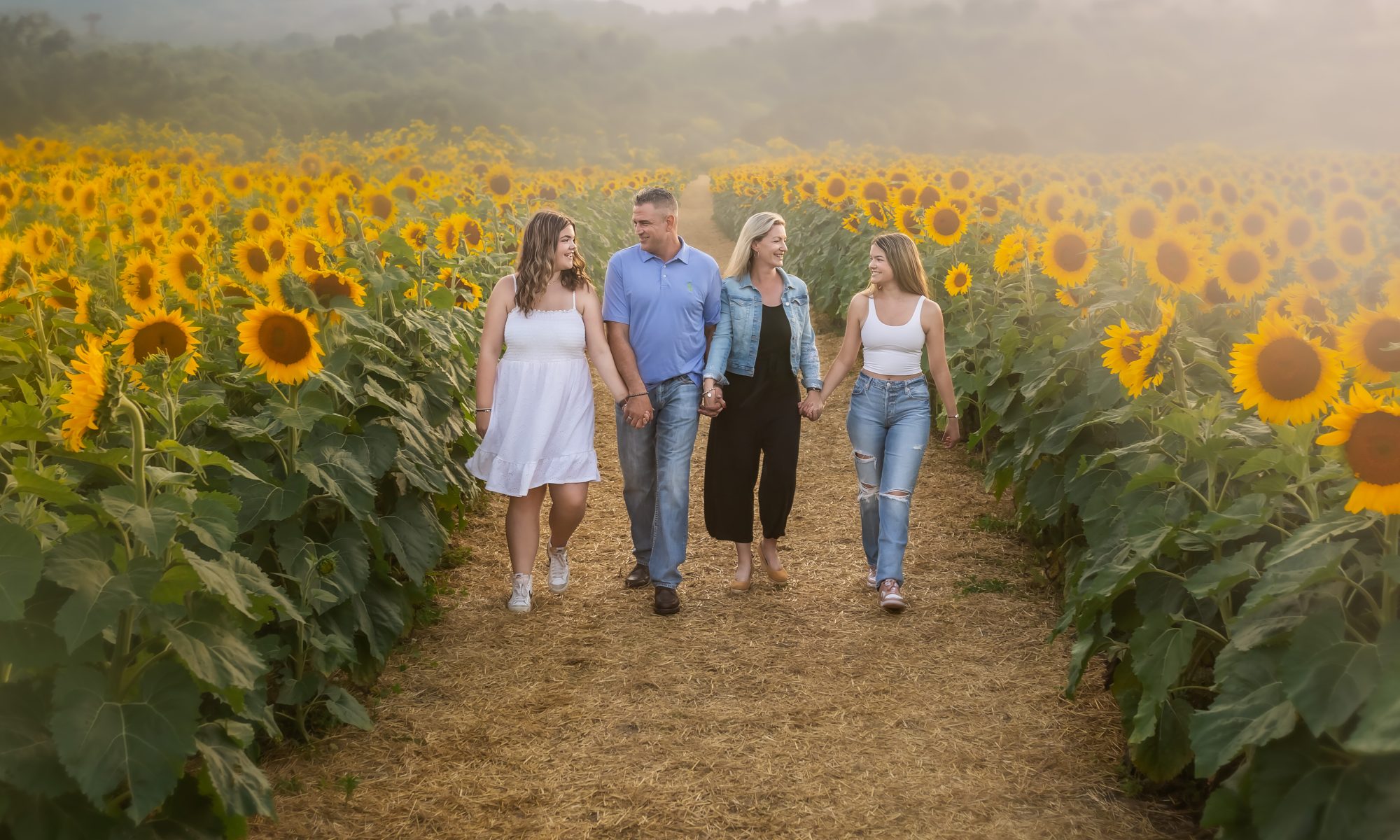 family walking through sunflower field